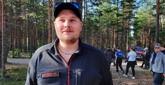 Antti Alarotu metsässä, taustalla retken osallistujia.